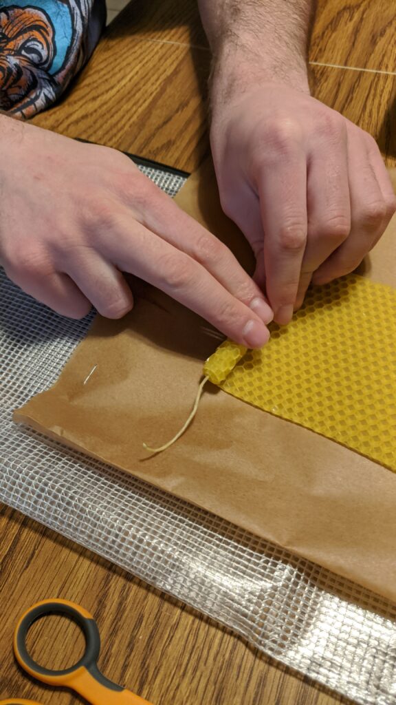 Place the wick on the short edge of the beeswax sheet and roll.
